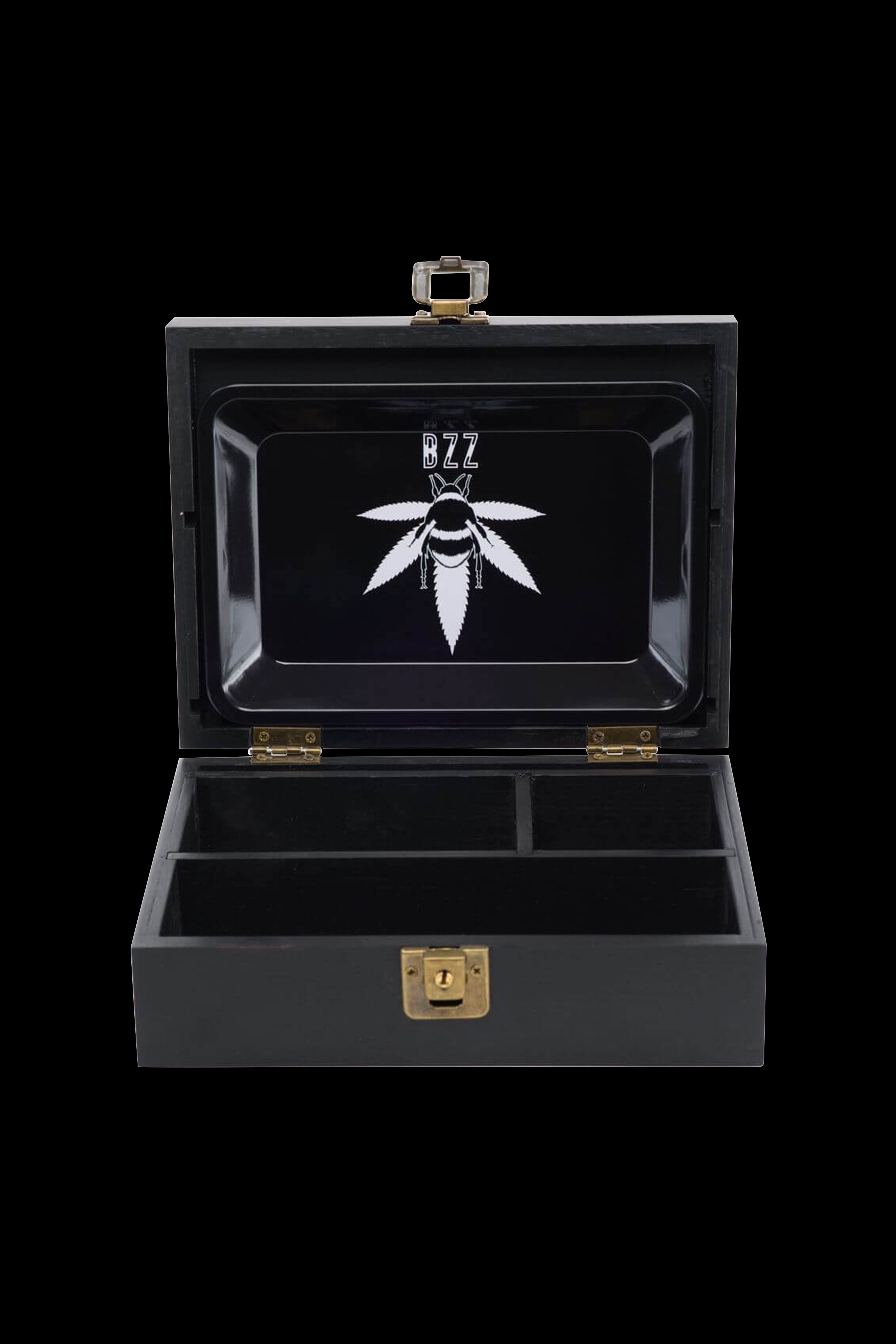 Black cannabis storage box with a leaf logo and internal compartments, open on a dark background.