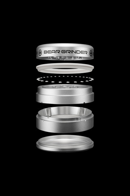 Exploded view of a silver cannabis grinder labeled "BEAR GRINDER", showcasing its disassembled components.