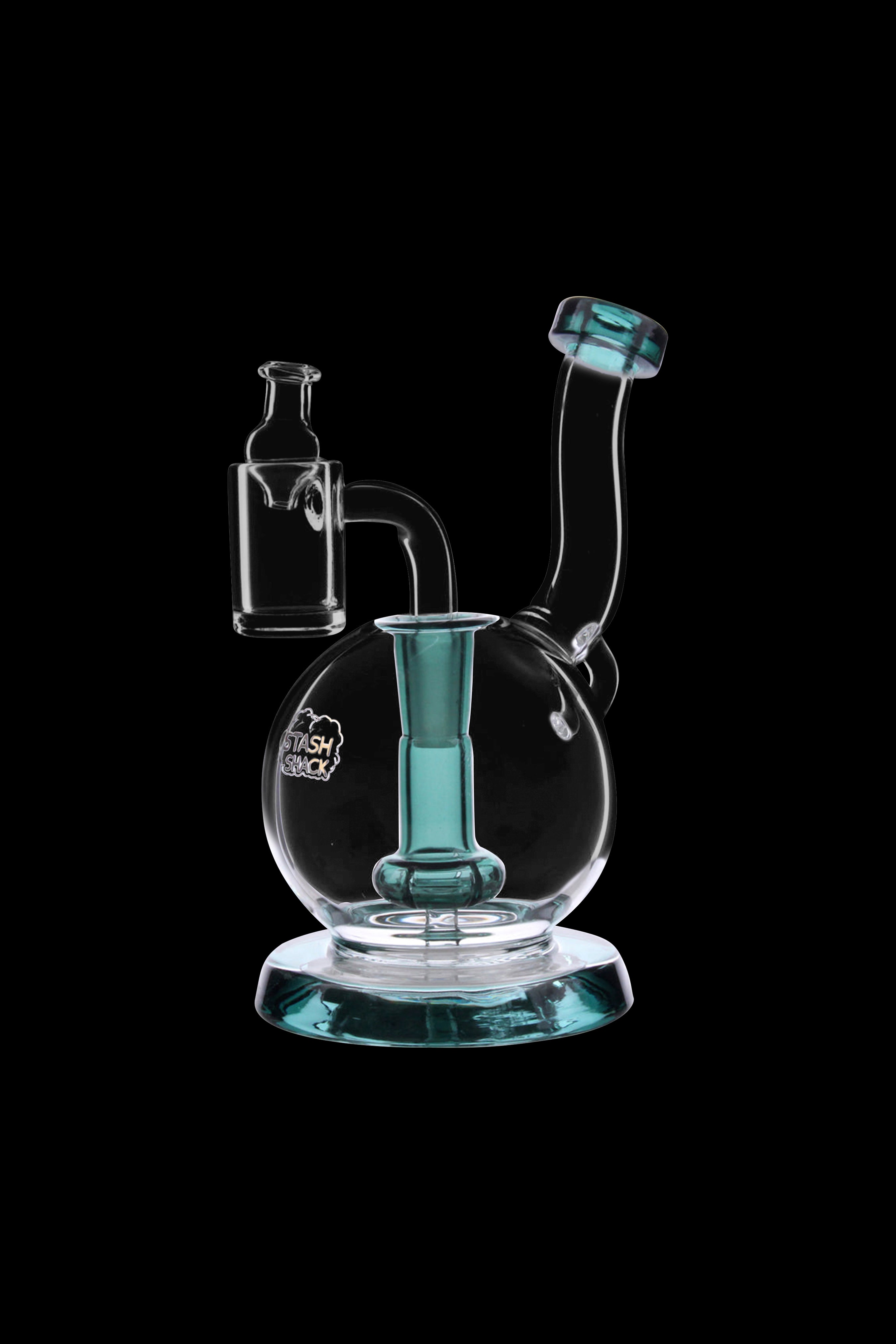 Clear glass dab rig with teal accents, featuring a bubbler base and accompanying glass carb cap.