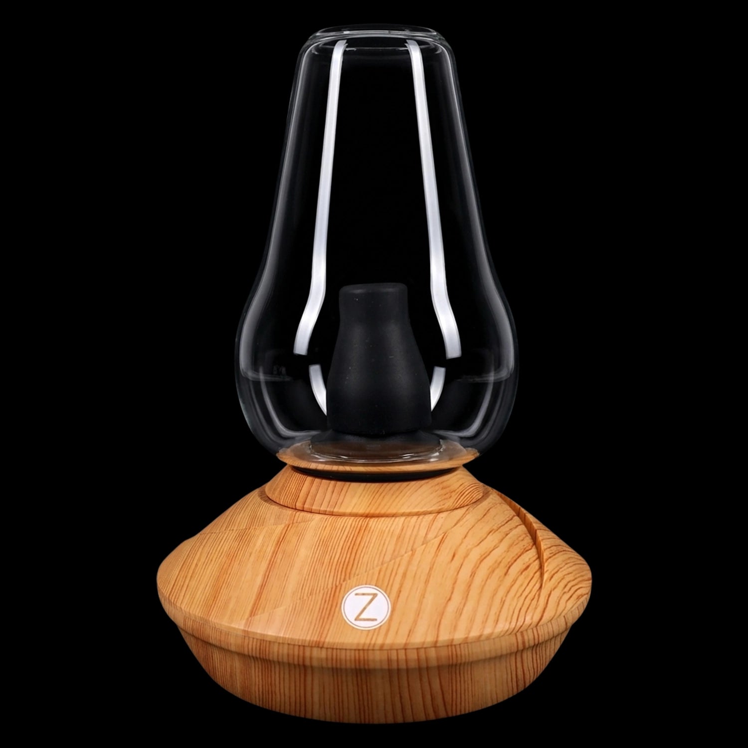 Front-facing close-up of the wood-colored Zenco Uno Desktop Vaporizer showing its glass bell chamber and black silicone insert atop a light wood grain base.