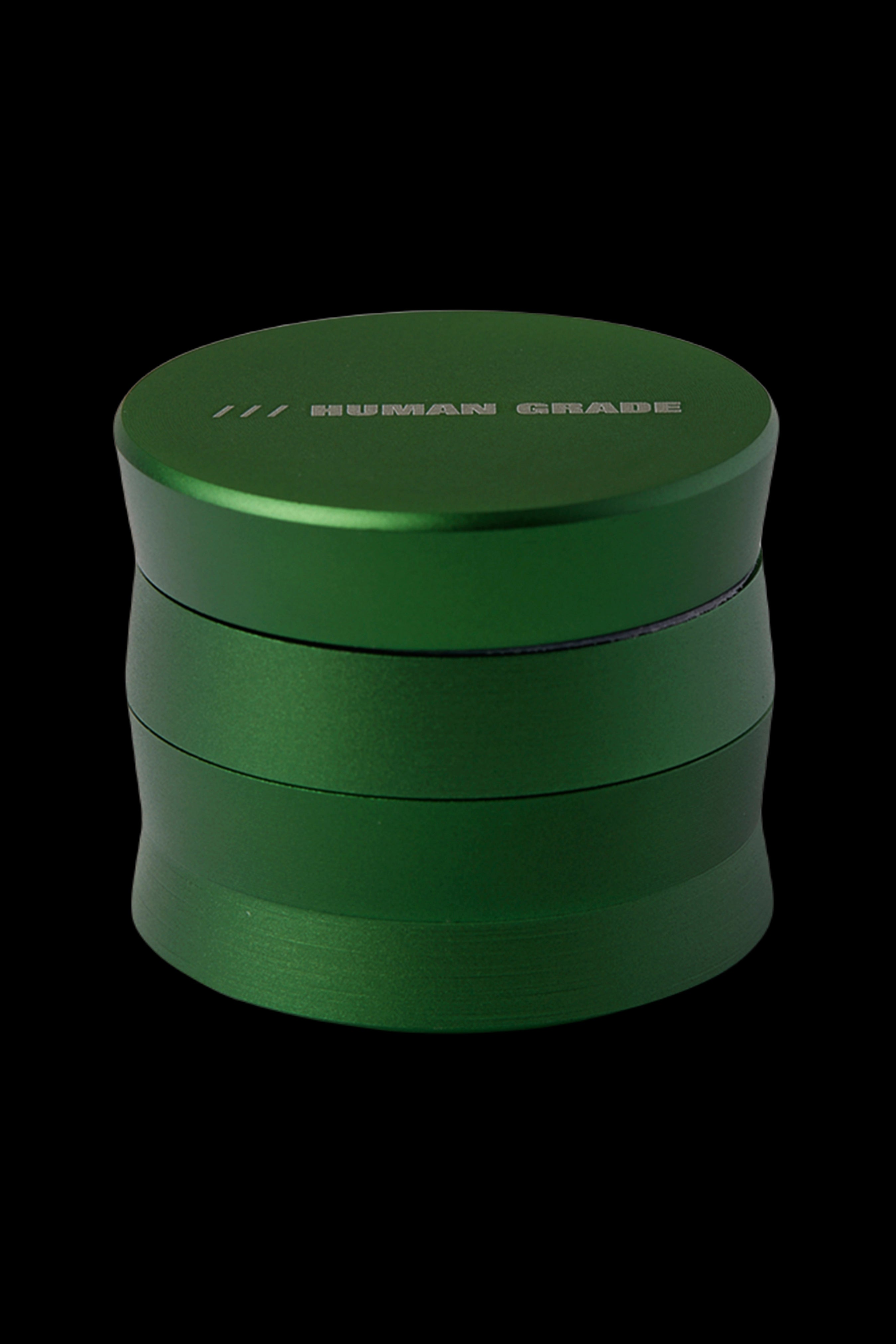 Green four-piece cannabis grinder with "HUMAN GRADE" etched on top.