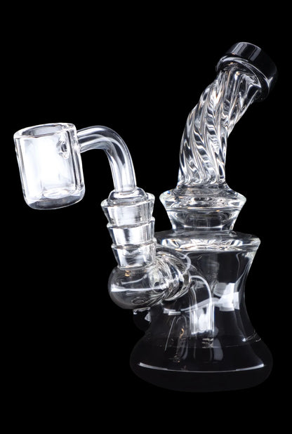 Clear glass dab rig with intricate bubbler design and quartz banger.