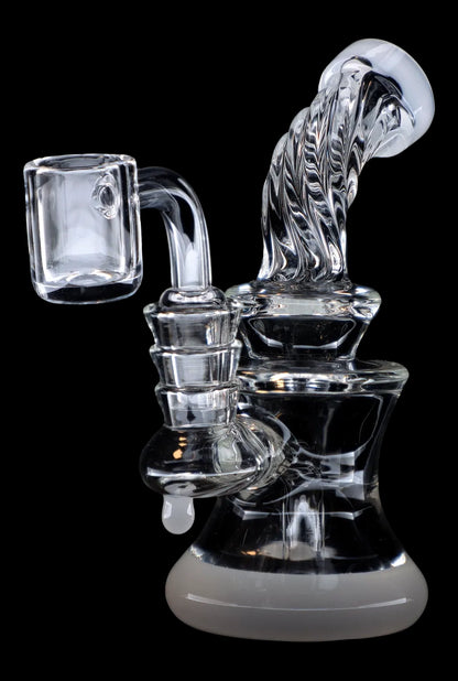 Clear glass dab rig with intricate swirls and a quartz banger, isolated on a black background.