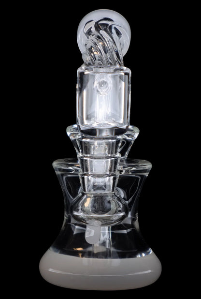 Clear glass dab rig with intricate sculpting and rounded base, isolated on a black background.