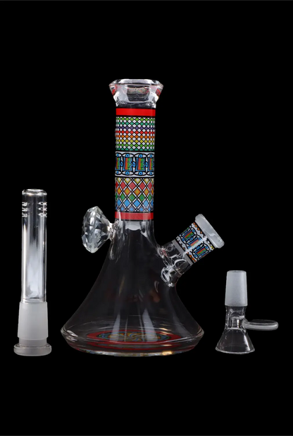 A colorful glass water pipe (bong) with Egyptian-inspired designs, displayed with a downstem and a separate glass piece, against a black background.