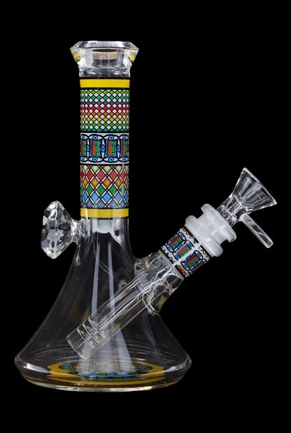 Glass bong with intricate geometric patterns and a clear base, isolated on a black background.