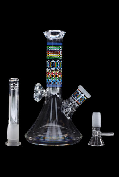 Glass water pipe (bong) with colorful geometric patterns and accompanying glass pieces on a black background.