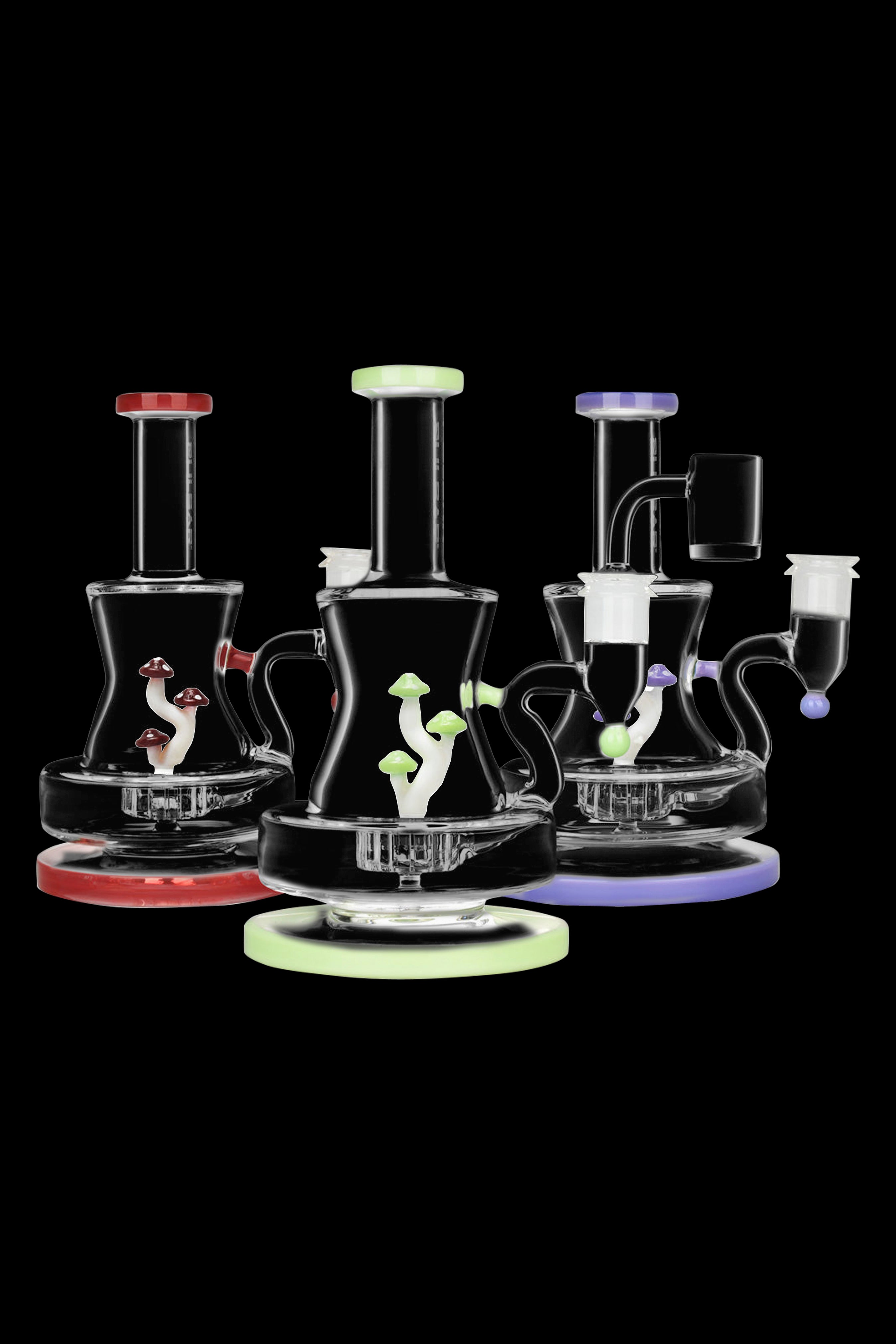 Glass rigs with mushroom-shaped percolators in red, green, and purple, displayed on glowing circular bases against a black background.