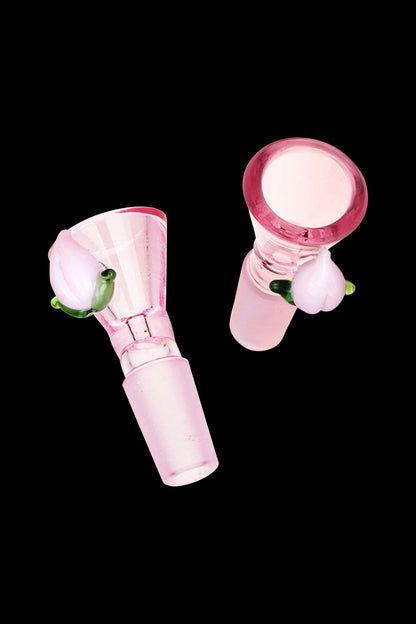 Pink glass bowl piece with green accents, isolated on a black background.