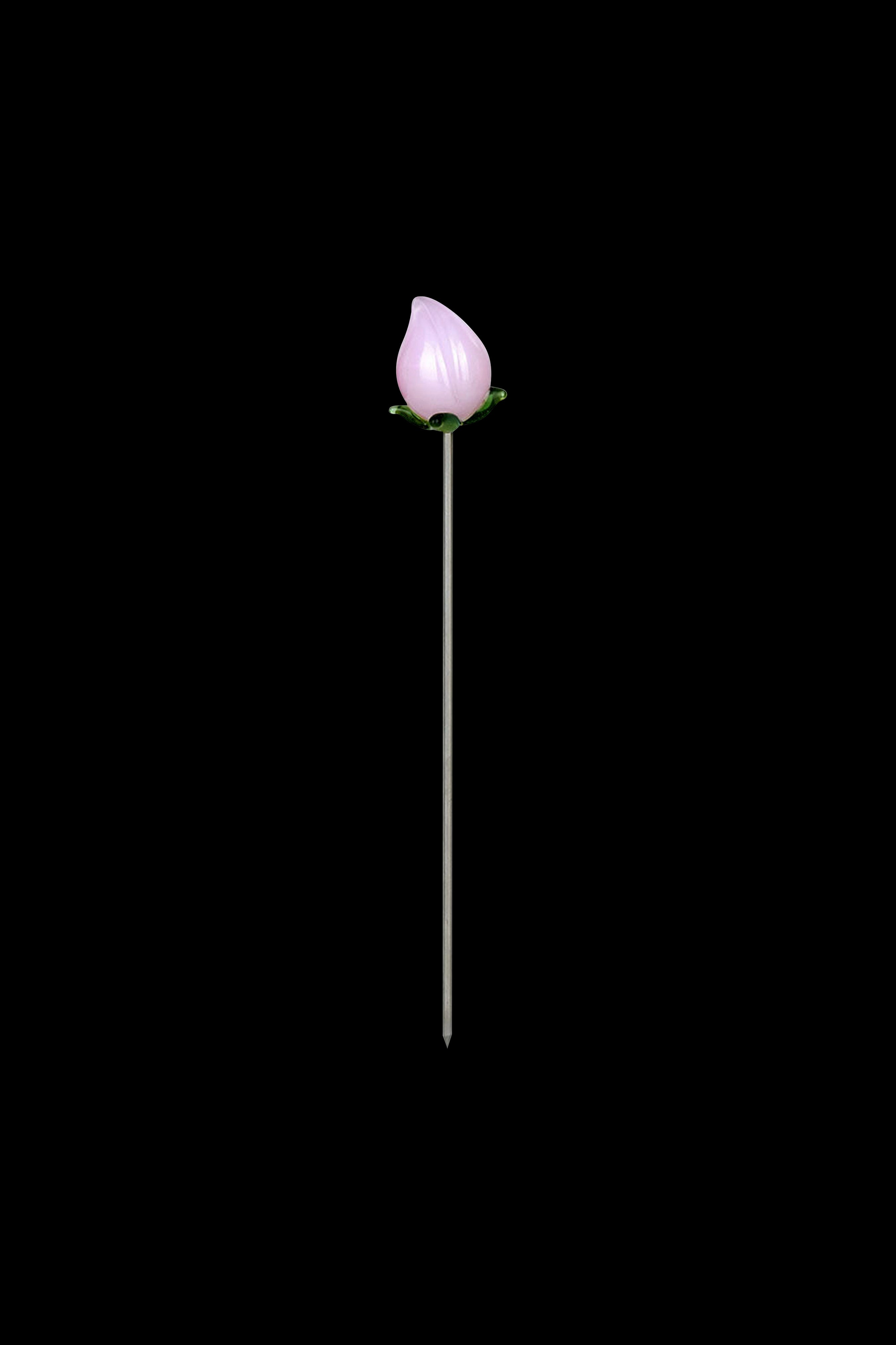 Pink glass cannabis oil burner tip on a thin metal stem against a black background.