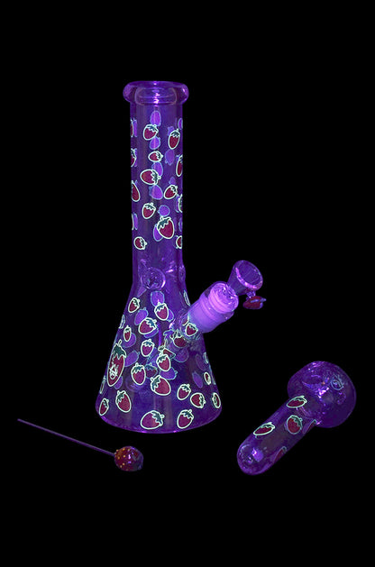 Purple glass water pipe and bowl with strawberry pattern, studio shot.