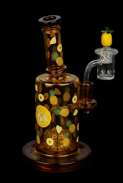 Three-quarter view of the amber glass Pulsar Fruit Series Pineapple Express Glow In The Dark Dab Rig Kit - 8" / 14mm F decorated with repeating pineapple graphics and a pineapple-topped clear quartz banger against a black background