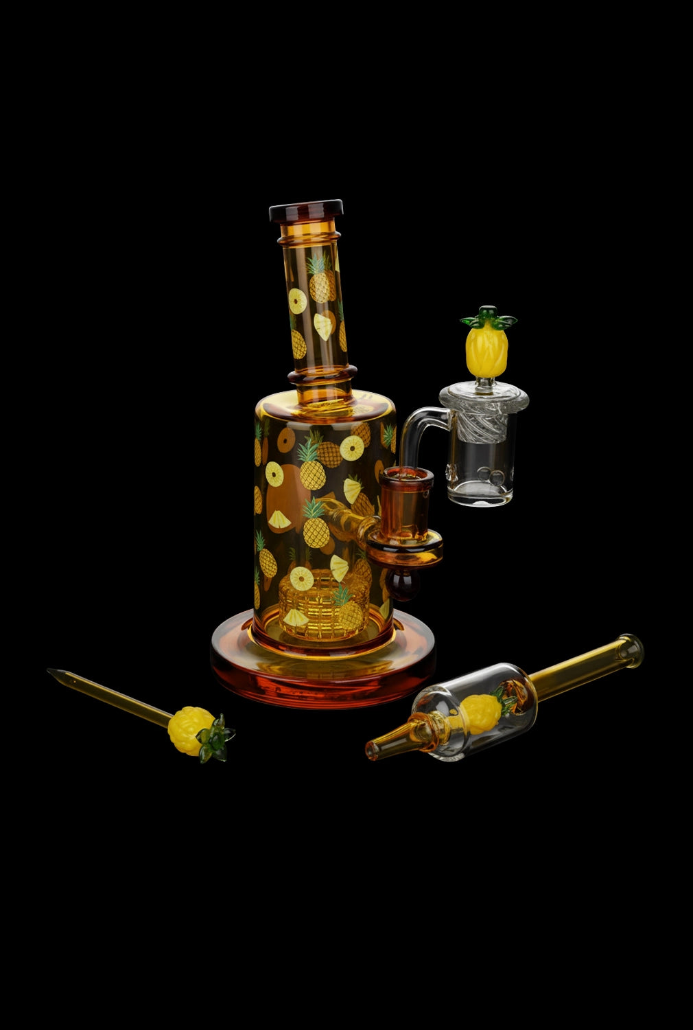 Studio front view of the Pulsar Fruit Series Pineapple Express Glow In The Dark Dab Rig Kit - 8" / 14mm F showing amber glass with pineapple motifs and matching tools on black.