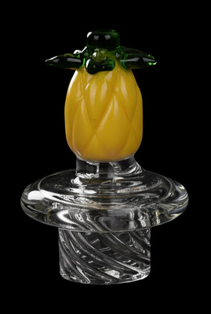 Close-up front view of a small pineapple carb cap on a clear glass base, shown against black for the Pulsar Fruit Series Pineapple Express Glow In The Dark Dab Rig Kit - 8" / 14mm F.