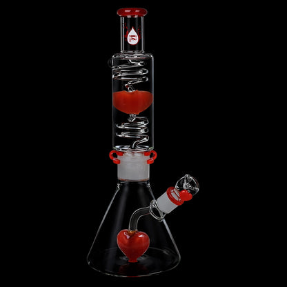 Studio-lit vertical view of the Pulsar Love Heart Beat Glycerin Beaker Glass Water Pipe - 14" / 19mm F showing a clear chamber with spiral percolator and red heart accents against a black background