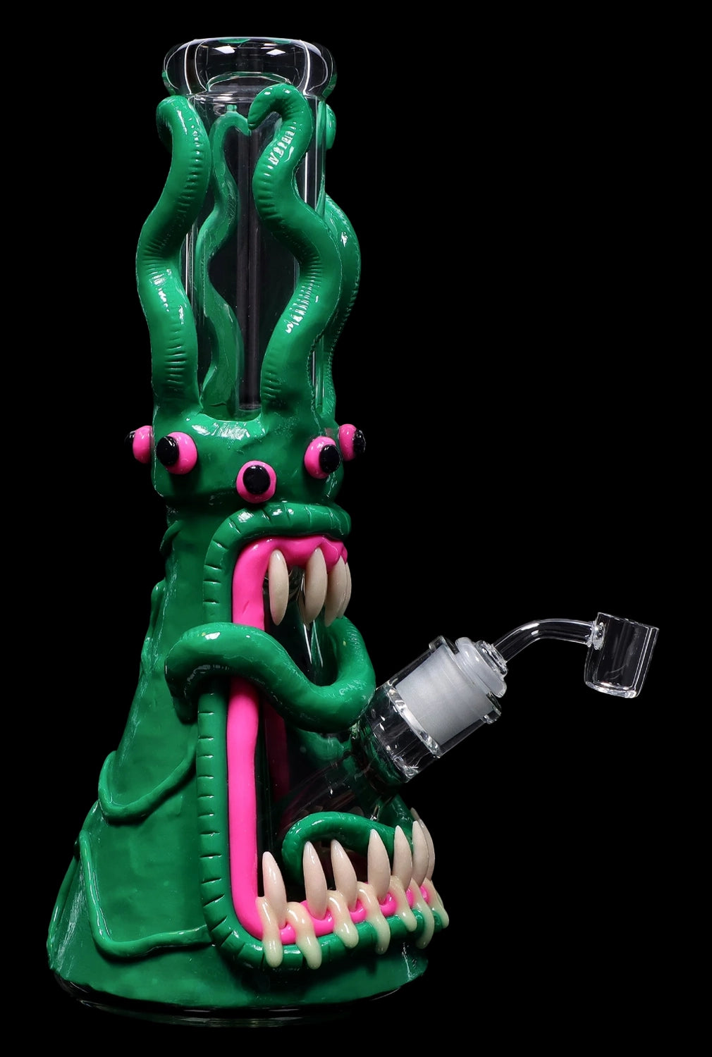 A vibrant green glass rig shaped like a monster with a wide-open mouth, pink tongue, and multiple tentacles, featuring a quartz banger for dabbing cannabis concentrates.