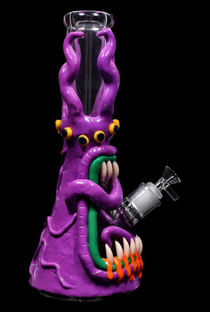 Purple glass bong shaped like a monster with tentacles and glowing eyes.