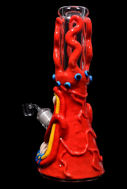 Red glass water pipe shaped like a monster with bulging eyes and colorful tentacles.