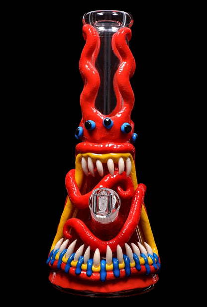 A vibrant red glass bong shaped like a monster with bulging blue eyes, sharp teeth, and colorful tentacles, set against a black background.