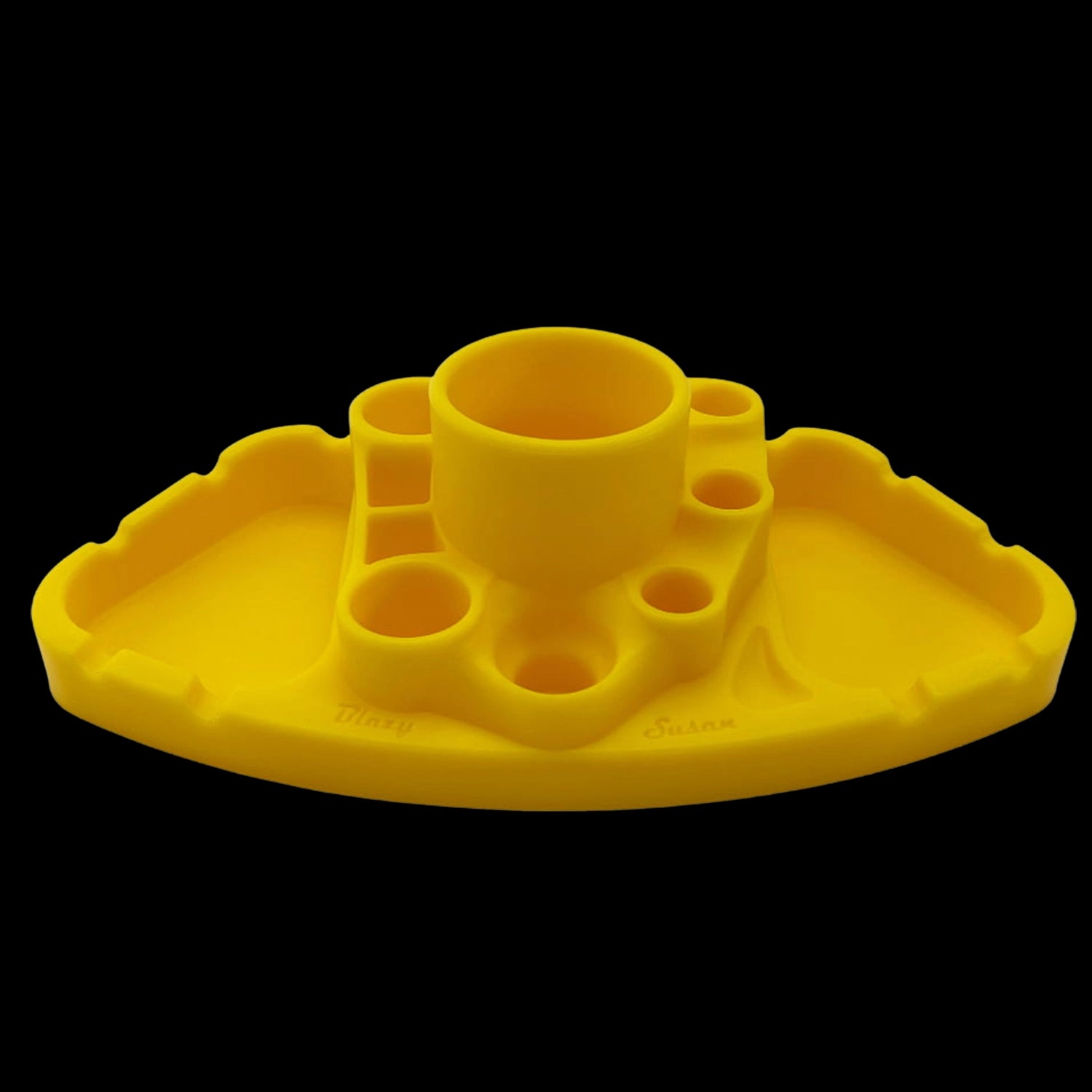 Front-facing close-up of a teal Blazy Susan Deluxe Dab Station showing its central cup and surrounding circular and rectangular wells against a black background