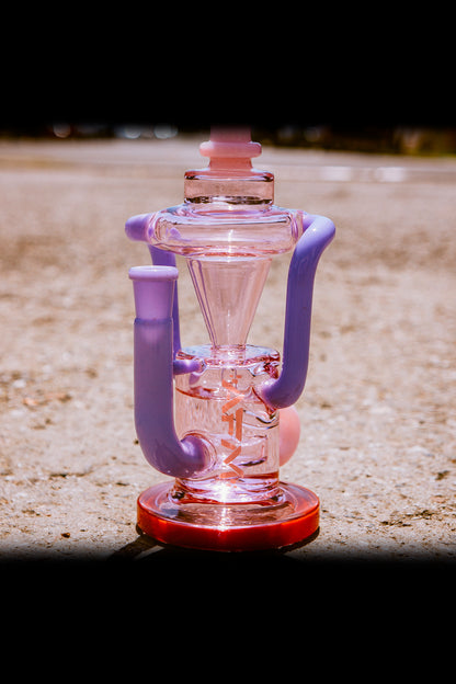Pink and purple glass water pipe with intricate bubbler design.