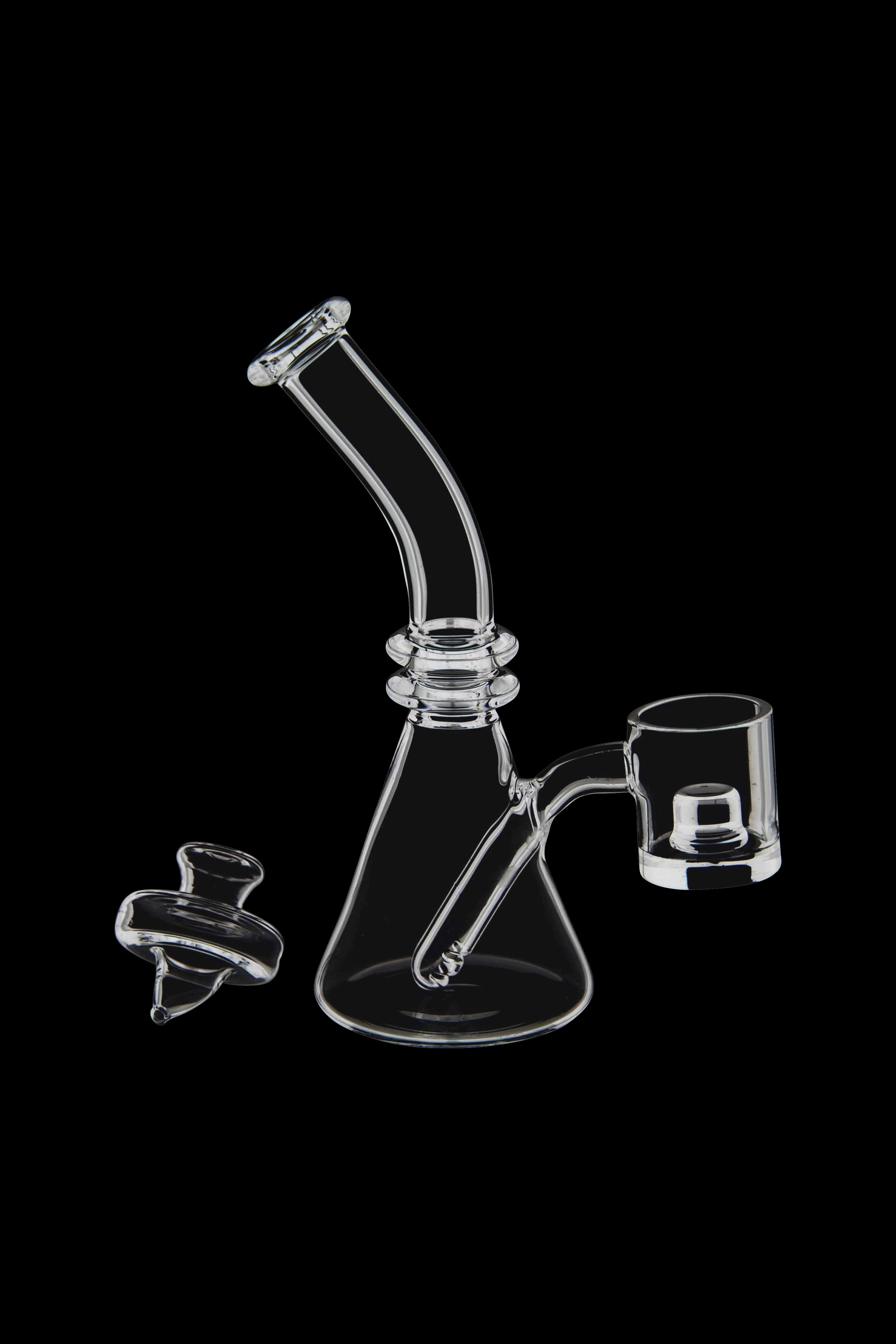 Clear glass dab rig with a quartz banger and carb cap, isolated on a black background.