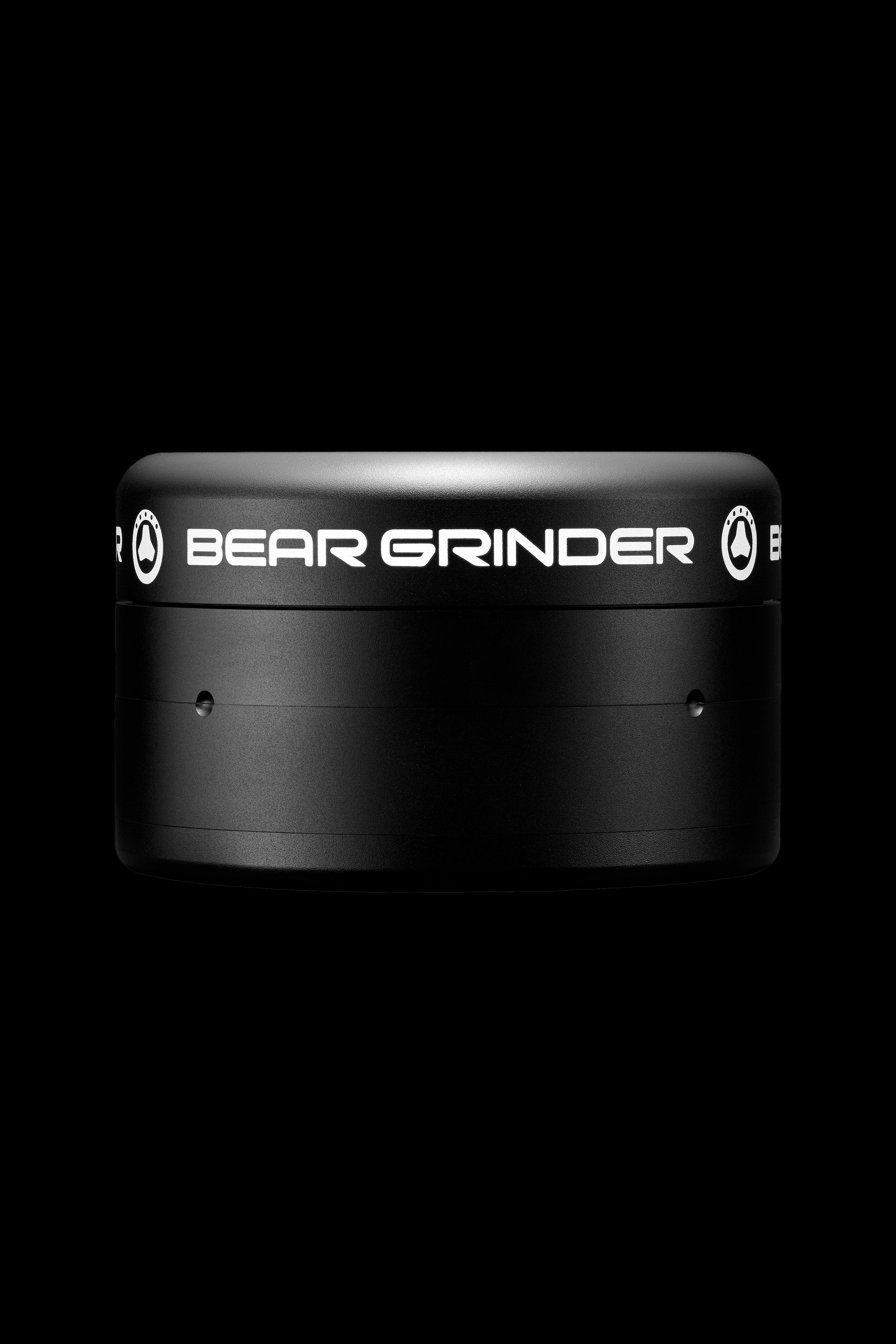 Black cannabis grinder with “BEAR GRINDER” text on a dark background.