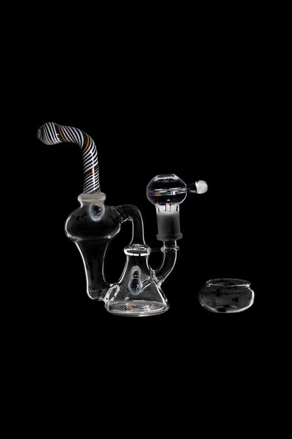 Glass water pipe (rig) with accompanying glass bowl, isolated on a black background.