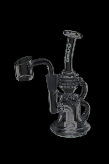 Clear glass dab rig with black accents and a quartz nail, isolated on a black background.
