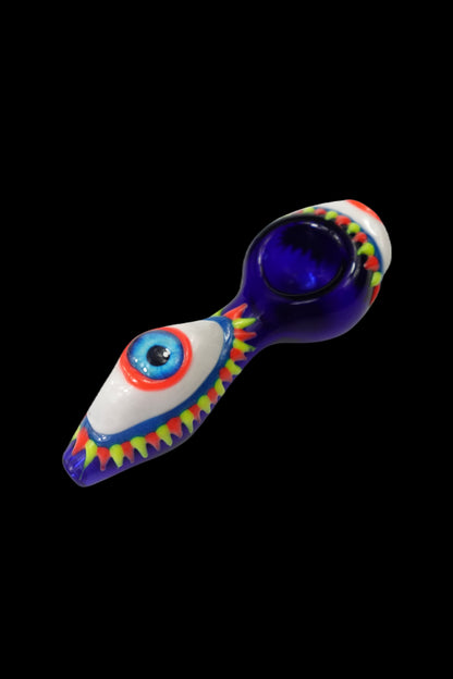 Colorful glass pipe shaped like an eye with a blue bowl, isolated on black.