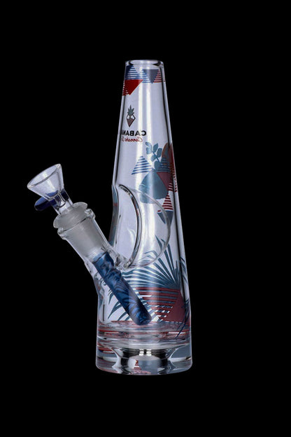 A glass water pipe (bong) with a colorful tropical leaf design and a blue mouthpiece, isolated on a black background.