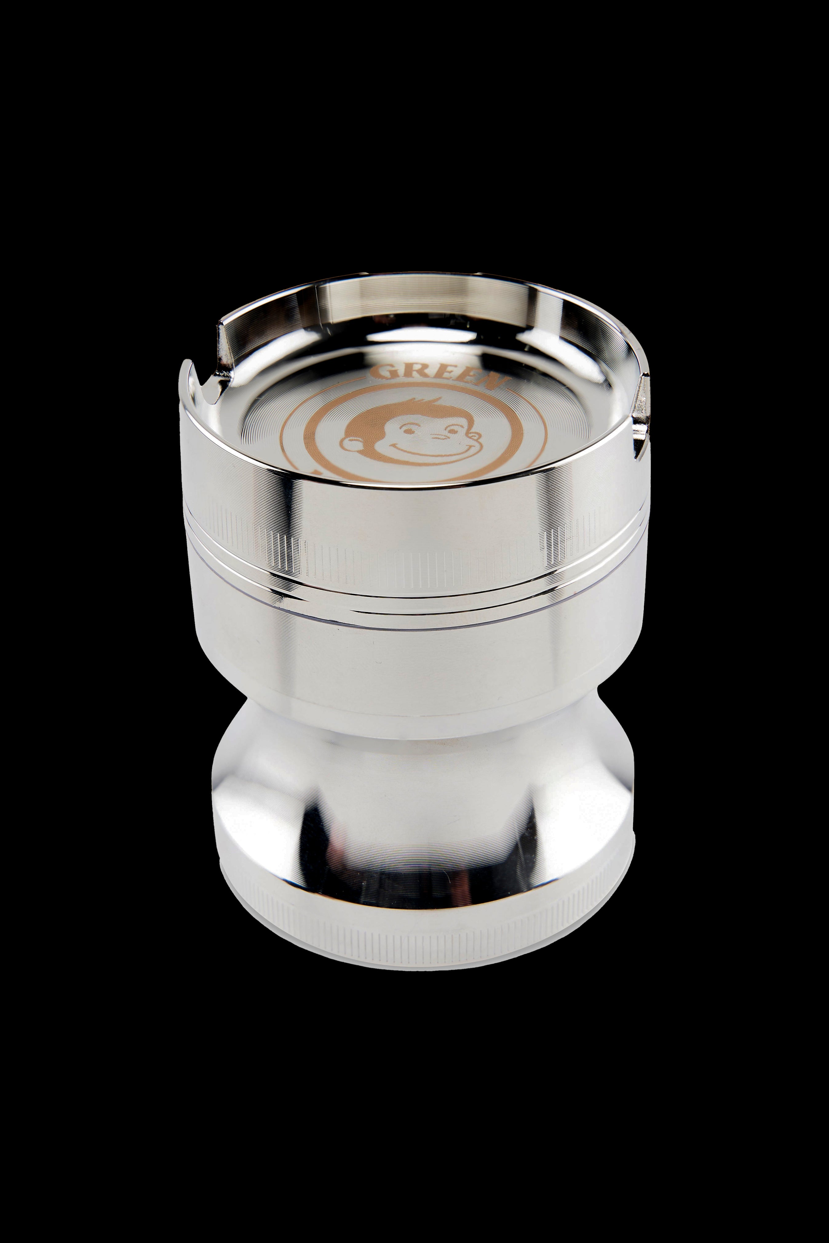 Top-down view of the metallic Green Monkey Chacma Grinder with Ashtray showing its shiny silver rim, engraved monkey logo and three notches.