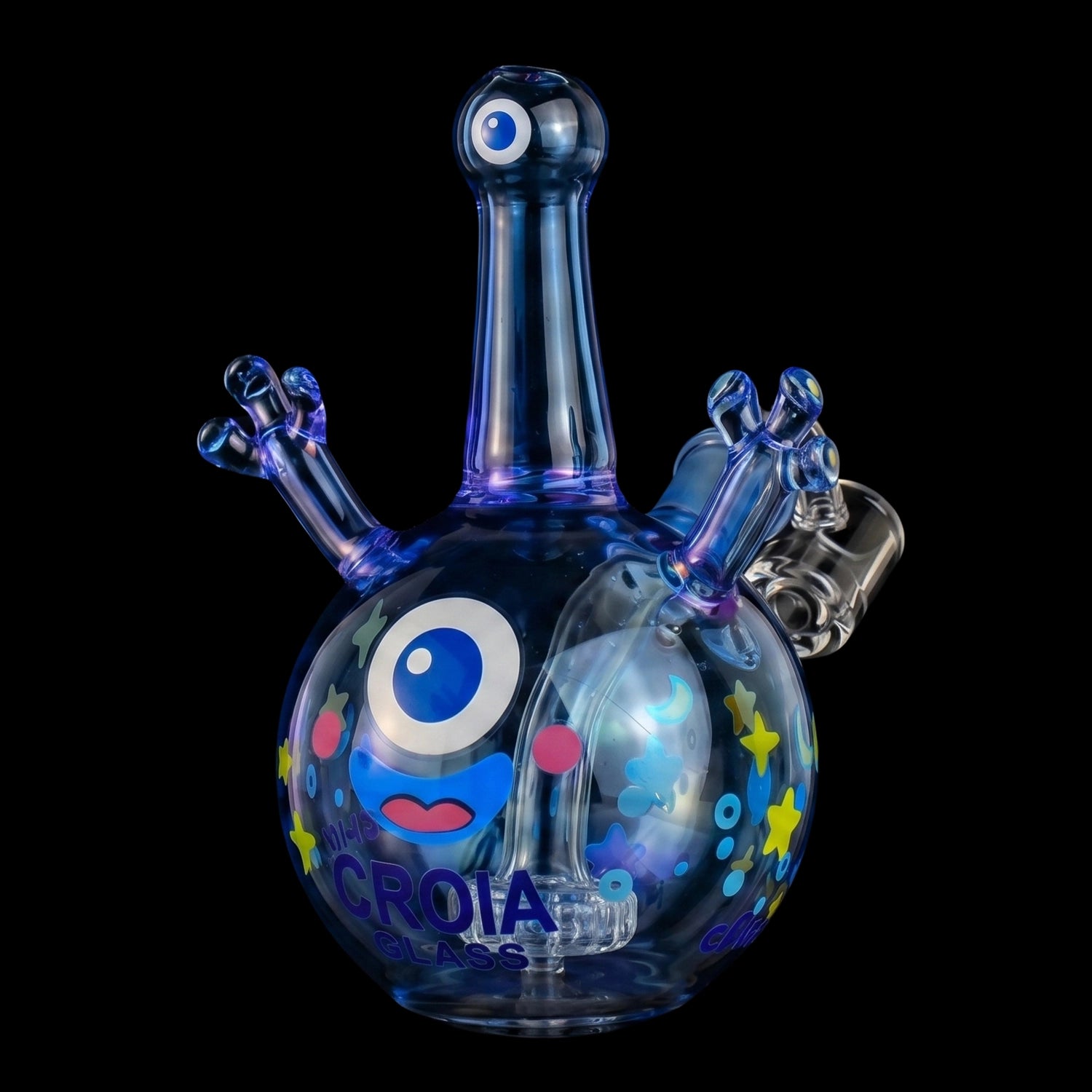 Close-up front view of the Croia Glass Cyclops Monster Mini Dab Rig with Showerhead Perc showing its glossy blue glass cyclops head and colorful star and eye decals against a black background.