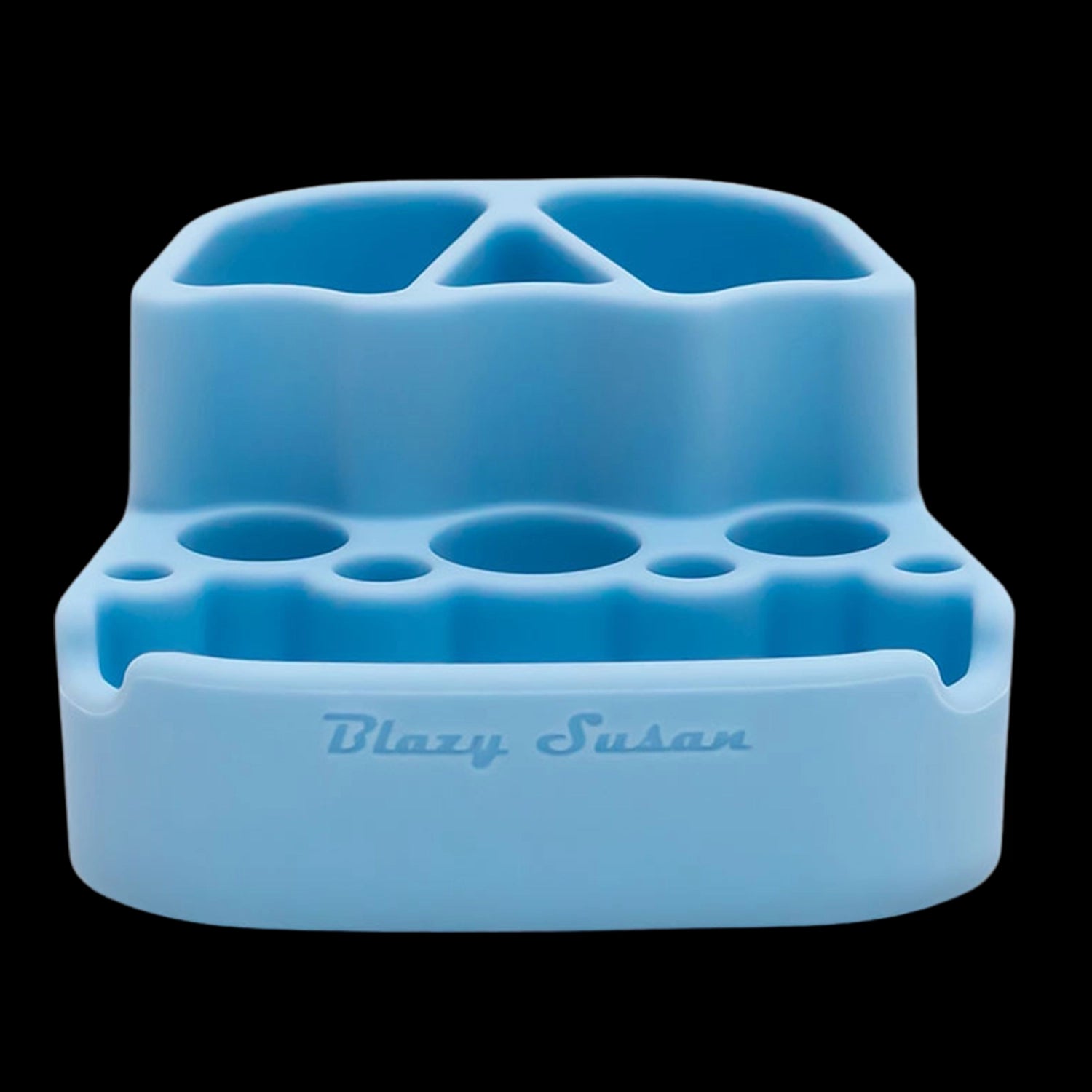 Close-up front view of a light blue Blazy Susan Dab Station showing multiple circular and triangular recessed holders and the embossed logo on a black background