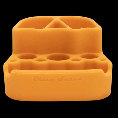 Close-up front view of the green Blazy Susan Dab Station showing its soft-edged silicone compartments and round tool slots against a black background.