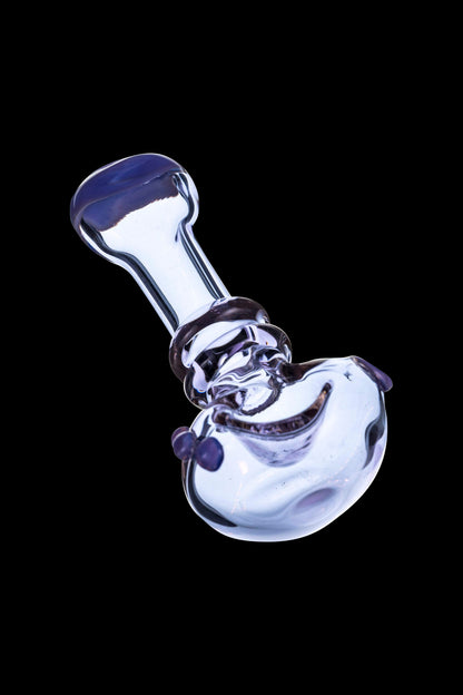 Purple glass bubbler pipe against a black background.