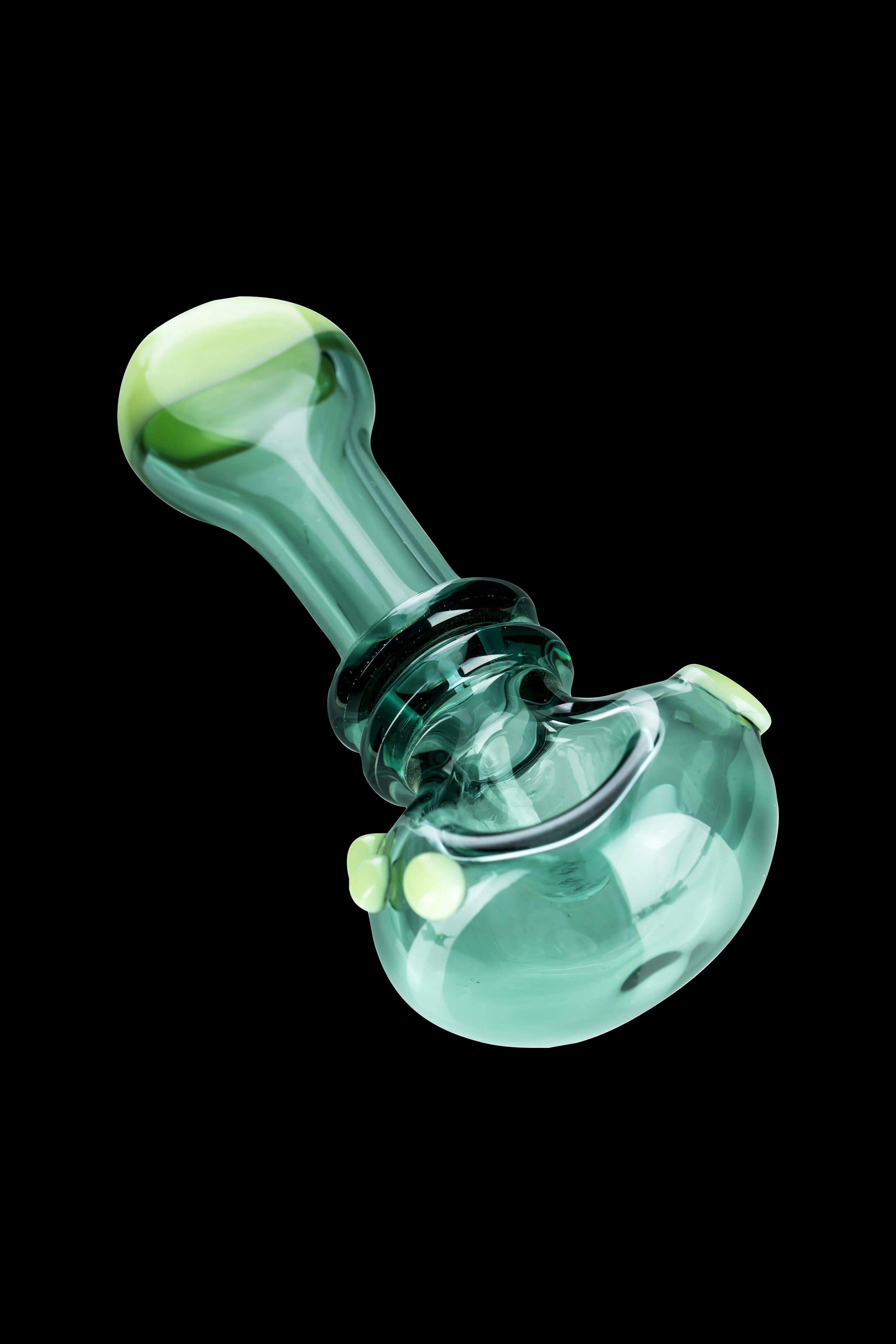 Green glass smoking pipe isolated on a black background.