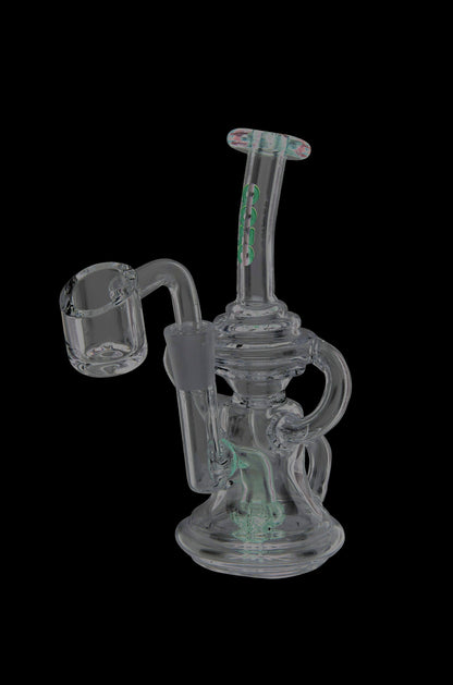A translucent glass dab rig with green accents and a quartz banger, isolated on a black background.