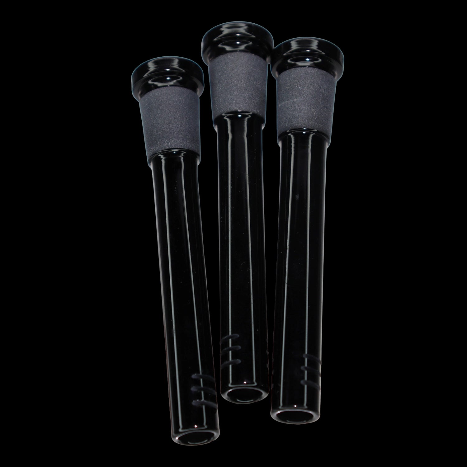 Close-up, slightly low-angle view of three black Smoke Cartel Color Diffused Downstem - 3.5 in. tubes with matte frosted joints against a black background