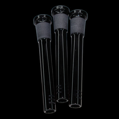 Close-up, slightly low-angle view of three black Smoke Cartel Color Diffused Downstem - 3.5 in. tubes with matte frosted joints against a black background