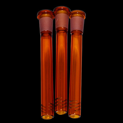Close-up front view of three amber Smoke Cartel Color Diffused Downstem - 4.5 in. tubes aligned vertically against a black background.