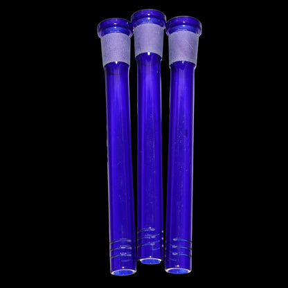 Close-up front view of three cobalt blue Smoke Cartel Color Diffused Downstem - 5 in. glass tubes aligned vertically against a black background.