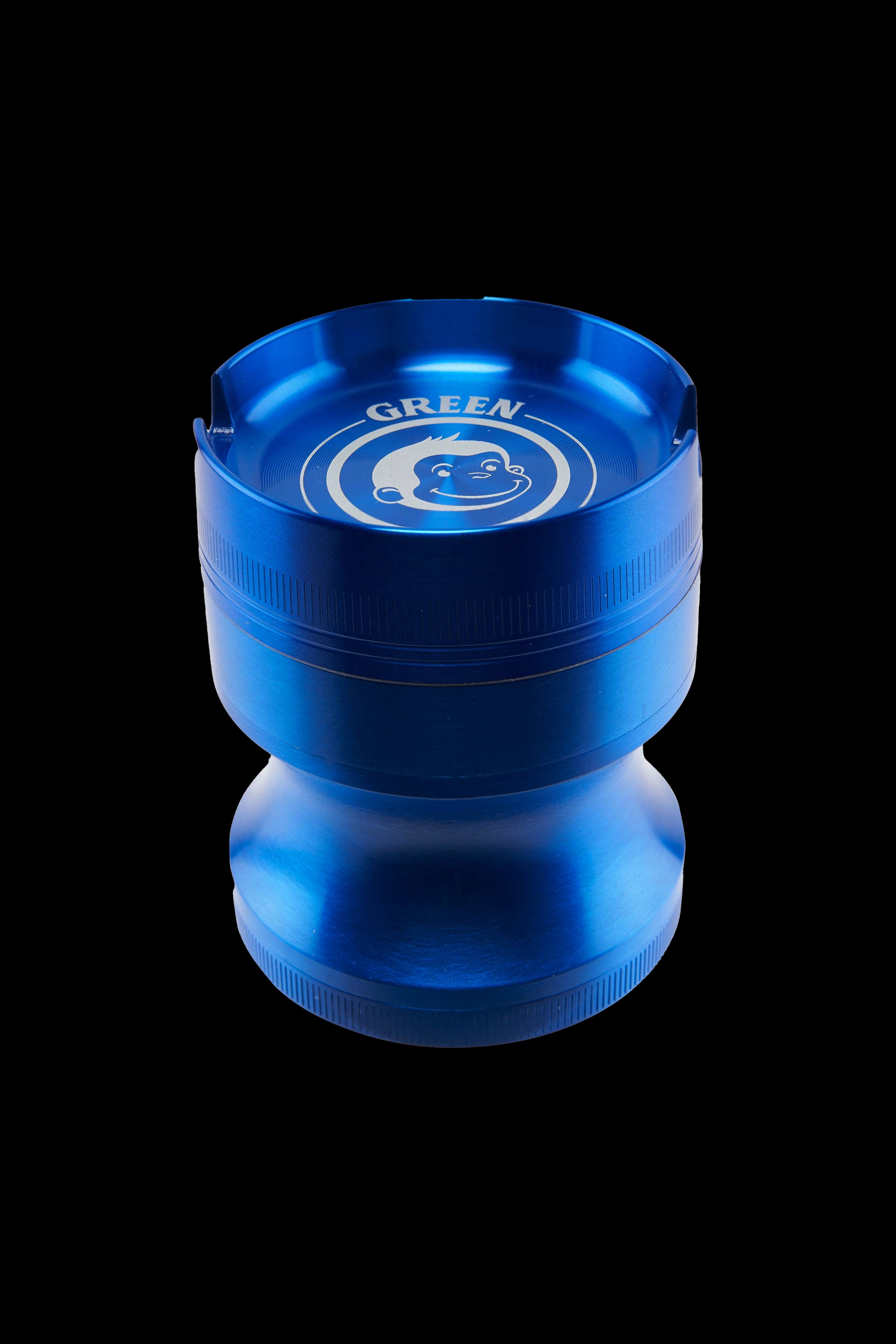 Close-up top-down view of a metallic blue Green Monkey Chacma Grinder with Ashtray showing its circular ashtray rim and smiling monkey logo.