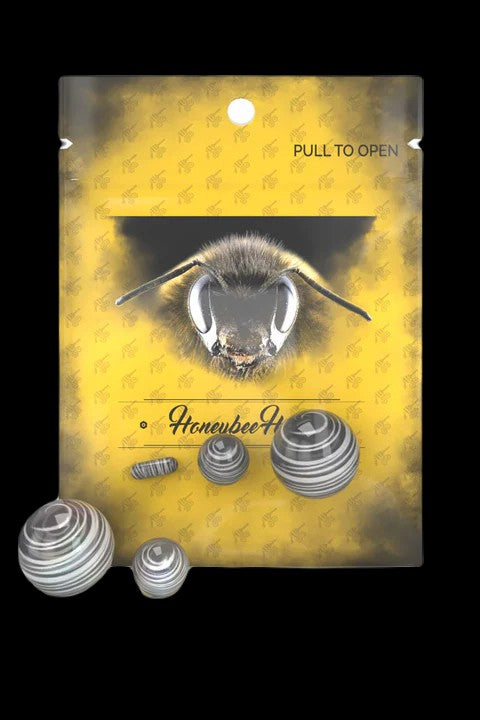 Yellow packaging for “Honeybee” cannabis accessories, featuring a close-up illustration of a bee’s face and several small, metallic filtering discs.
