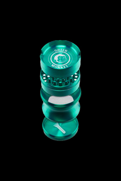 Top-down view of a gunmetal Green Monkey Chacma Grinder with Ashtray showing its stacked four-piece sections, visible teeth, mesh screen and monkey logo.