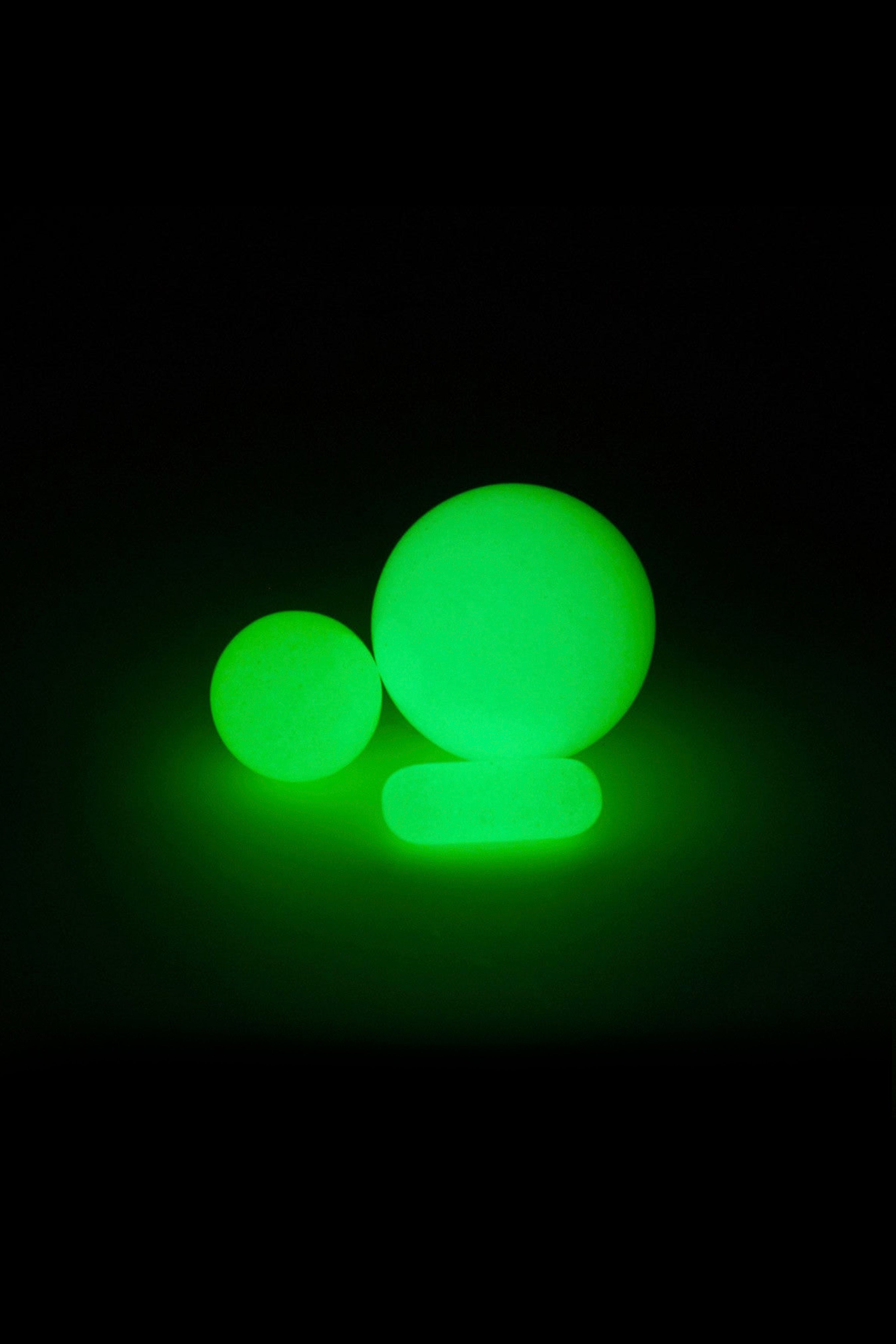 Glowing green spheres resembling cannabis buds against a black background.