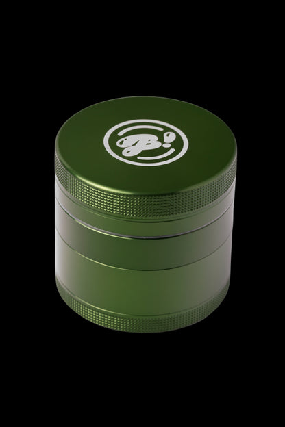 Olive green four-piece metal grinder with a logo on the lid.