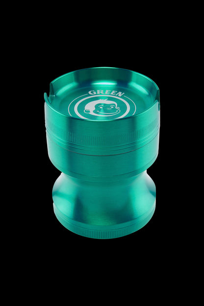 Close-up, top-down view of the Green Monkey Chacma Grinder with Ashtray in metallic green showing the recessed ashtray rim and monkey logo.