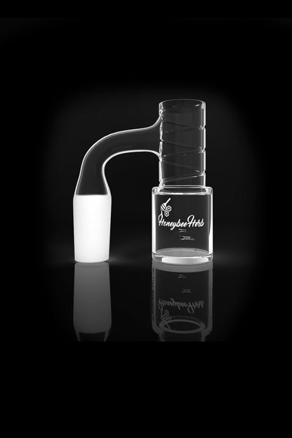 Clear glass water pipe with "Honeybee Herb" logo, studio shot on a reflective black surface.