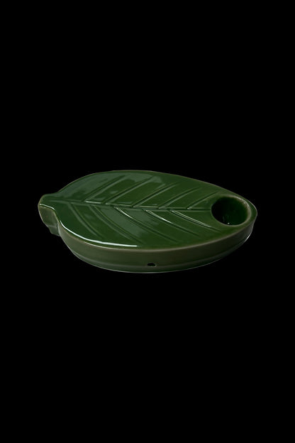 Green ceramic ashtray shaped like a cannabis leaf with a bowl-shaped indentation.